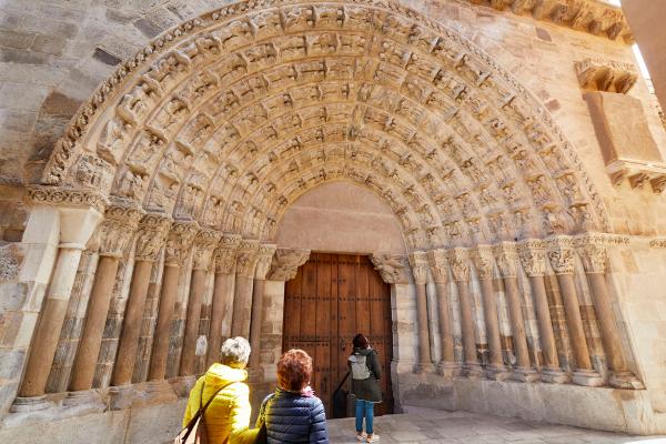 Tres personas delante de la puerta del Juicio de la catedral de Tudela